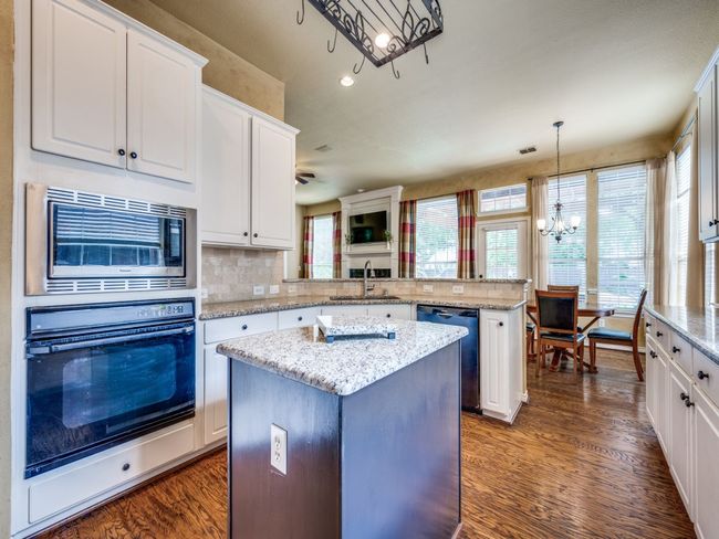 Kitchen featuring oven, dishwasher and stainless steel microwave, and a center island | Image 12