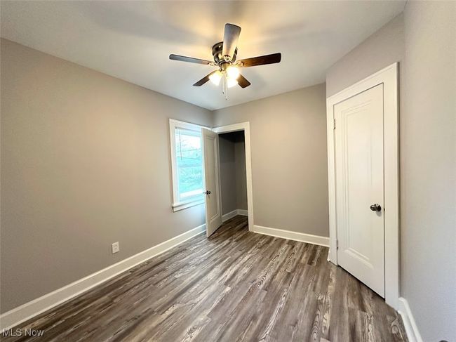 Unfurnished bedroom featuring dark wood-style flooring, ceiling fan, and baseboards | Image 8