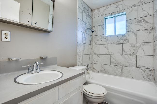 Bathroom with toilet, shower combination, and vanity | Image 22