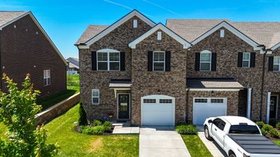 All brick end unit townhome with one car garage, driveway, and guest parking around the corner. | Image 2