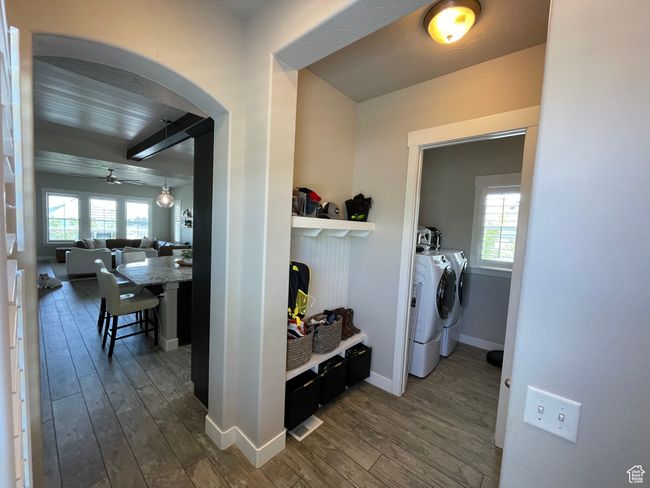 Hall with arched walkways, mudroom nook, laundry room, and wood-style tile | Image 17