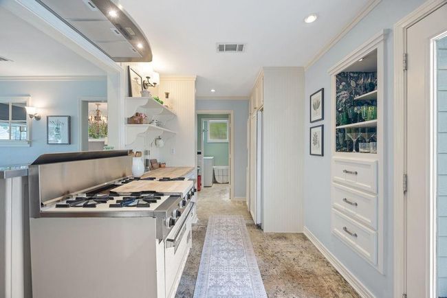 View of the kitchen, looking toward the laundry room and half bathroom. Notice the vintage Viking range! | Image 10
