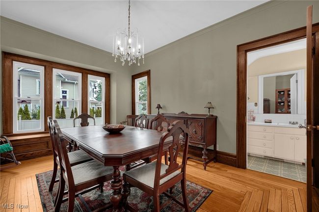 Dining room featuring hardwood floors, baseboards, ornamental molding, and chandelier | Image 8