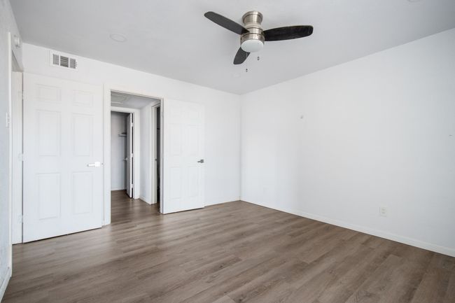 Empty room featuring ceiling fan and dark wood-type flooring | Image 13