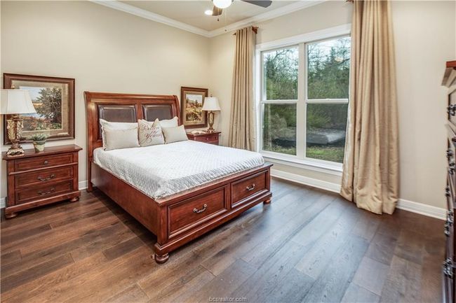 Bedroom featuring baseboards, ornamental molding, dark wood-style floors, and ceiling fan | Image 26