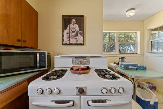 Kitchen featuring stainless steel microwave, range with two ovens, and brown cabinetry | Image 11