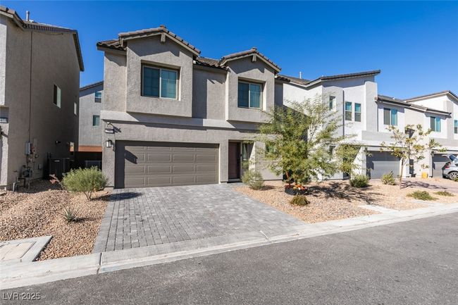 View of front facade featuring stucco siding, a residential view, a tiled roof, decorative driveway, and a garage | Image 40
