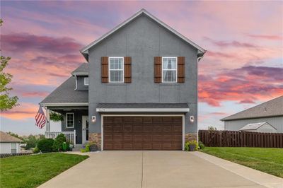 View of front facade featuring a garage, covered porch, and a lawn | Image 3