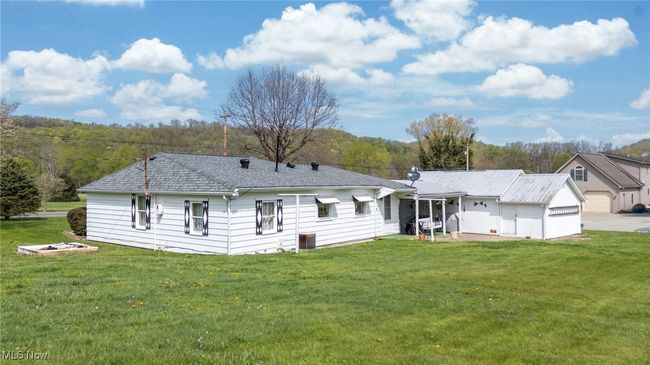 Rear view of property featuring a garage and a yard | Image 38