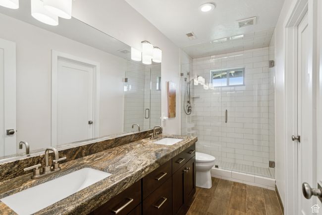 Bathroom featuring wood finished floors, a stall shower, and double vanity | Image 27