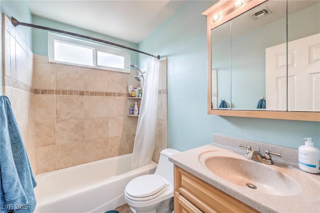 Bathroom featuring visible vents, toilet, vanity, and shower / bath combo | Image 36