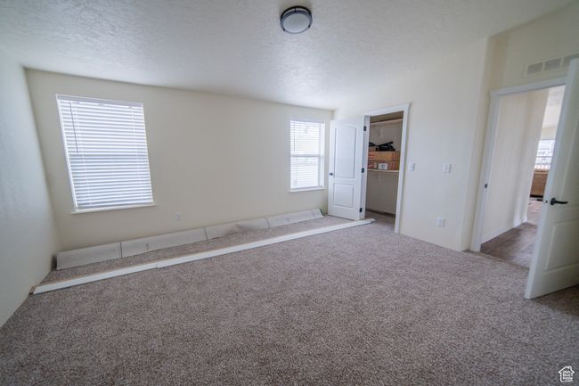 Spare room with a textured ceiling, vaulted ceiling, visible vents, and carpet flooring | Image 18