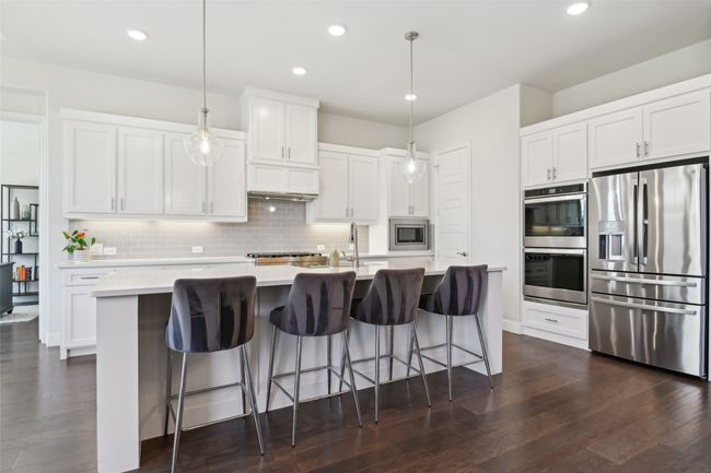 Kitchen with appliances with stainless steel finishes, tasteful backsplash, light countertops, dark wood finished floors, and recessed lighting | Image 16