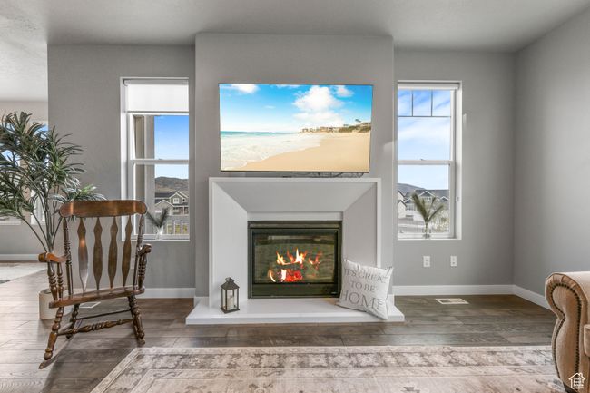 Sitting room with baseboards, a glass covered fireplace, and hardwood / wood-style floors | Image 9