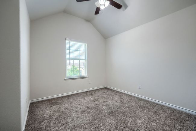 Carpeted spare room featuring a ceiling fan, vaulted ceiling, and baseboards | Image 28
