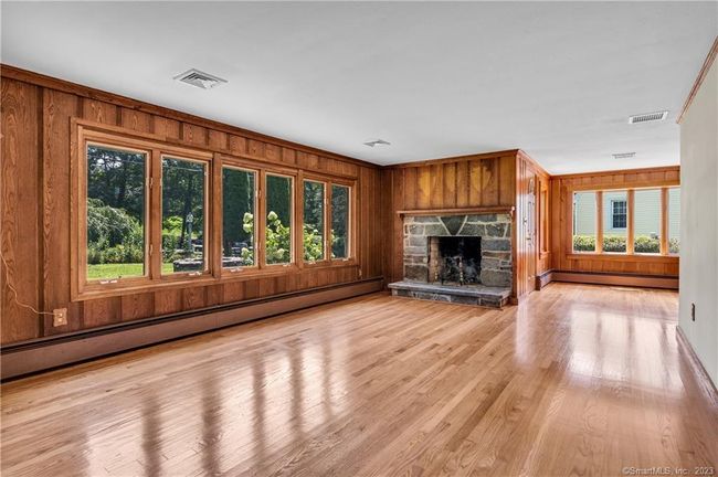 The Living Room, with a bank of windows has the second Fireplace. | Image 13