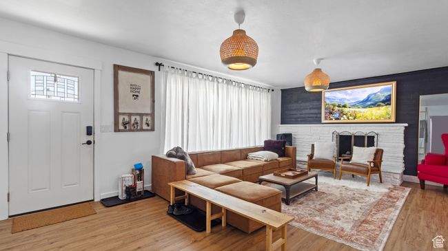 Living area featuring light wood-style floors, a brick fireplace, and baseboards | Image 22