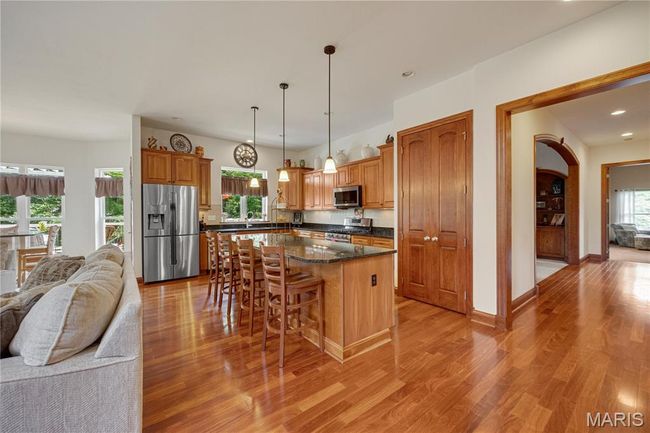 Kitchen with appliances with stainless steel finishes, open floor plan, a breakfast bar area, light wood-style flooring, and recessed lighting | Image 16