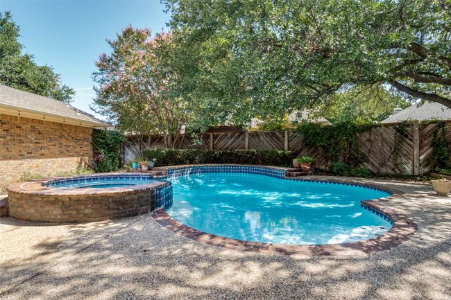 View of pool featuring a fenced backyard and a pool with connected hot tub | Image 24