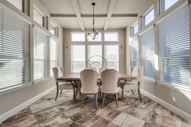 Dining space featuring coffered ceiling, beamed ceiling, and a chandelier | Image 15