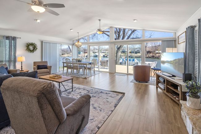Living room with a ceiling fan, lofted ceiling, and wood finished floors | Image 6