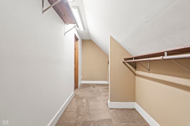 spacious closet with light carpet and lofted ceiling | Image 36