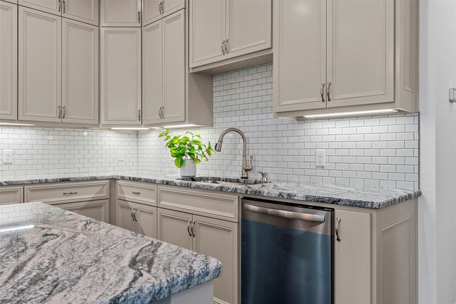 Kitchen featuring dishwasher, backsplash, and light stone countertops | Image 10