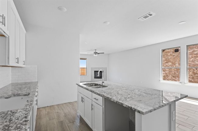 Kitchen with plenty of natural light, sink, ceiling fan, and a center island with sink | Image 4