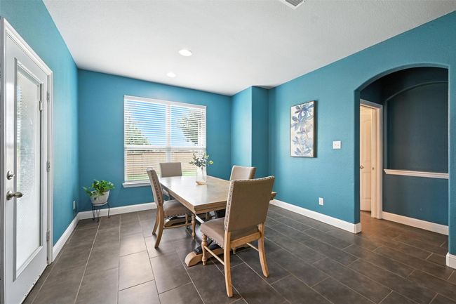 Dining area featuring arched walkways, recessed lighting, and dark tile patterned flooring | Image 15