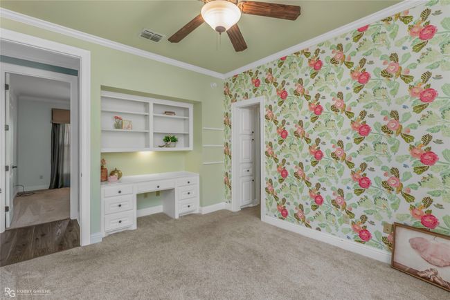 Bedroom has a large walkin closets along with bookshelving and desk. | Image 20