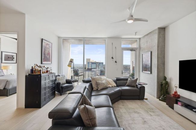Living area featuring floor to ceiling windows, light wood finished floors, and ceiling fan | Image 10