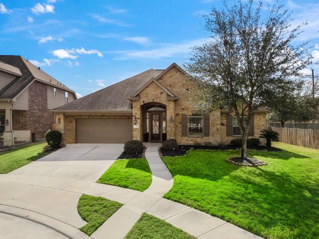 Located in a peaceful cul-de-sac, this single-story home features a timeless brick and stone exterior. The covered archway entry invites you into elegant interiors, while the 3-car tandem garage provides ample parking. Set amidst lush landscaping, the property offers refined living in the Spring Trails community with top-notch amenities. | Image 8