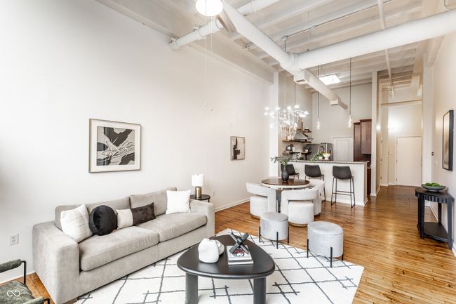 living area with a towering ceiling and light wood-style flooring | Image 6
