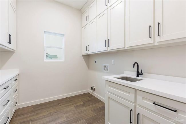Laundry room with washer hookup, sink, cabinets, and hookup for an electric dryer | Image 22