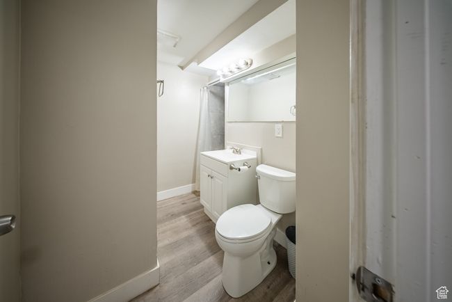 Bathroom featuring vanity, wood finished floors, and a shower with curtain | Image 20