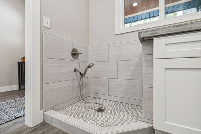 Full bath featuring tiled shower and wood finished floors | Image 32