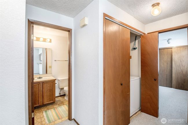 Main bathroom, closet with Washer/dryer in hallway. | Image 11