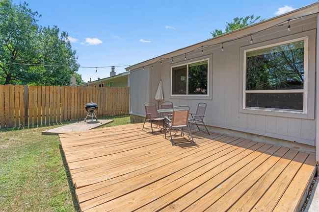 Wooden deck featuring a fenced backyard and outdoor dining area | Image 27