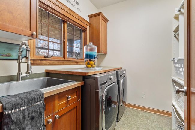 Laundry with included recent LG washer and natural gas LG dryer. Deep laundry tub, clothes sorting counter and storage shelves. | Image 17
