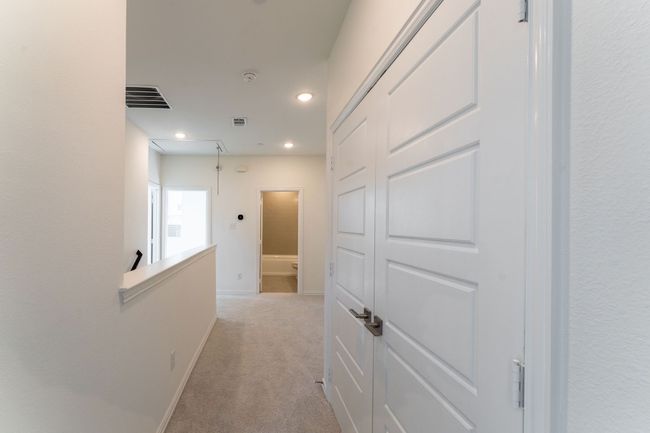 Hall featuring light colored carpet, baseboards, visible vents, and recessed lighting | Image 12