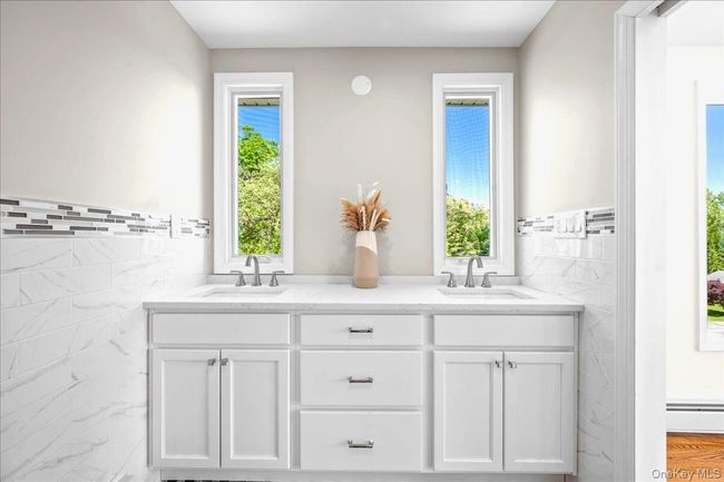 Bathroom featuring tile walls, a wainscoted wall, and double vanity | Image 23