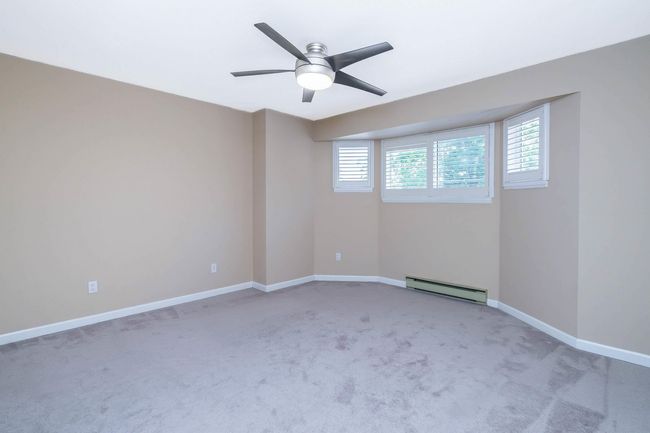 Unfurnished room with light carpet, a baseboard radiator, ceiling fan, and baseboards | Image 20