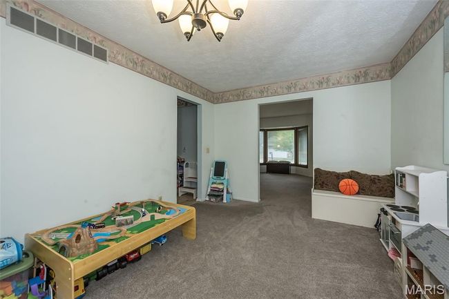 Recreation room with a chandelier, carpet flooring, and a textured ceiling | Image 9