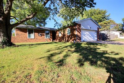 View of front facade with a garage and a front yard | Image 1