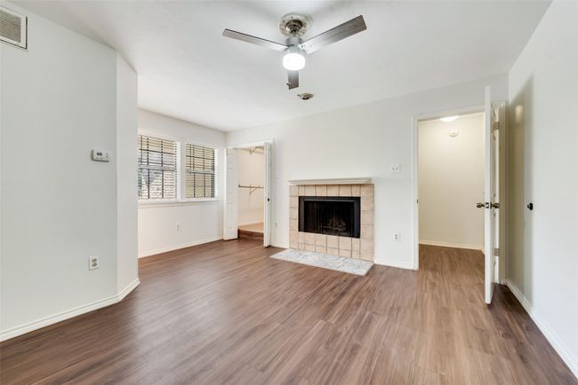 Unfurnished living room with wood finished floors, a tile fireplace, and a ceiling fan | Image 17