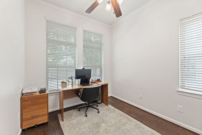Office space with a ceiling fan, ornamental molding, dark wood-style floors, and baseboards | Image 5