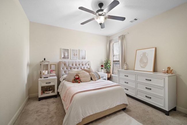 This cozy bedroom offers a serene retreat with soft tones and plush carpeting. Large windows fill the space with natural light, creating a warm and inviting atmosphere ideal for relaxation or personalization. | Image 26