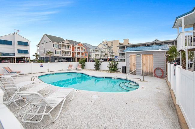 Community pool featuring a fenced backyard, a residential view, a patio, and an outbuilding | Image 4