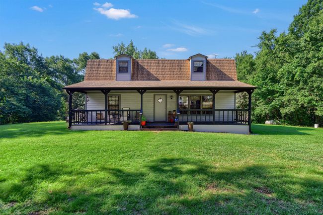 Rear view of property featuring a lawn, covered porch, and roof with shingles | Image 29