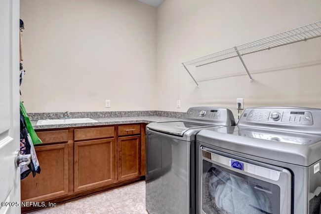 Laundry room with stainless washer and dryer and built-in cabinets and countertop | Image 29